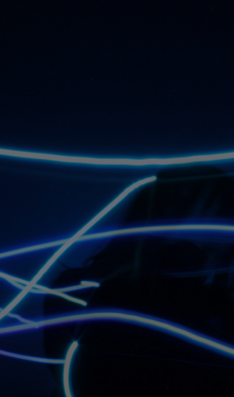 A woman holding her head, surrounded by bright, blurred, blue neon lights.