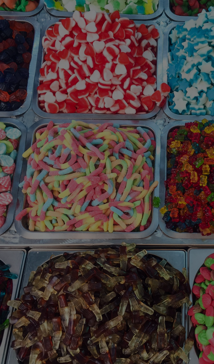 Assorted metal bins filled to the brim with various candies.